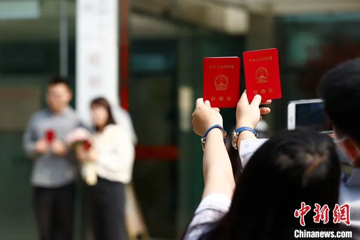 2021年5月20日,一对新人手持结婚证在北京海淀区民政局婚姻登记处外拍照留念。<a target='_blank' href='/'>中新社</a>记者 富田 摄 2021年5月20日,一对新人手持结婚证在北京海淀区民政局婚姻登记处外拍照留念。<a target='_blank' href='/'>中新社</a>记者 富田 摄